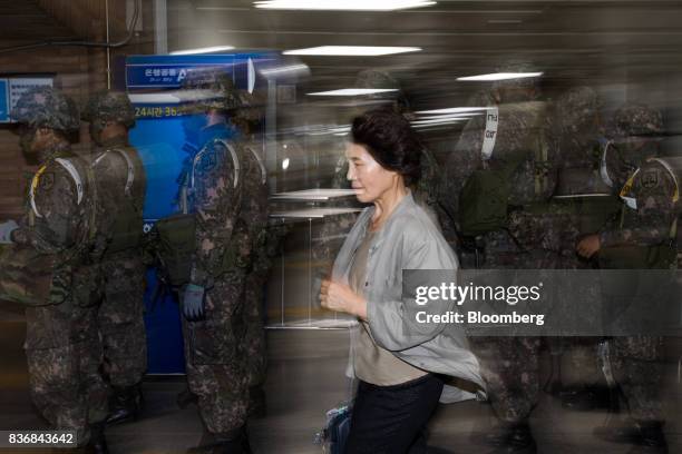 Passenger runs past soldiers standing guard during an anti-terror drill on the sidelines of the Ulchi Freedom Guardian military exercises at a subway...