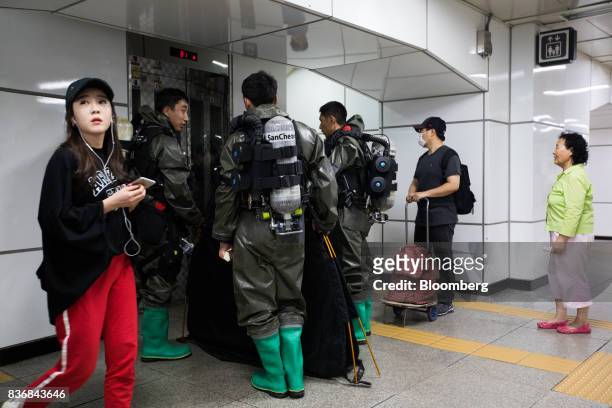 Woman walks past soldiers standing at an elevator during an anti-terror drill on the sidelines of the Ulchi Freedom Guardian military exercises at a...