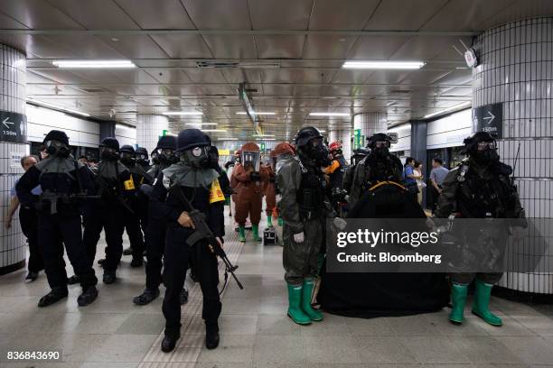 Police officers, left, and soldiers wearing gas masks participate in an anti-terror drill on the sidelines of the Ulchi Freedom Guardian military...