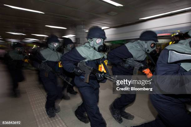 Police officers wearing gas masks participate in an anti-terror drill on the sidelines of the Ulchi Freedom Guardian military exercises at a subway...