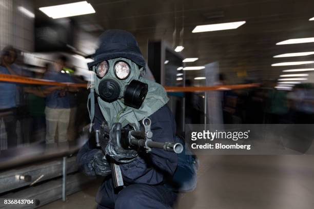Police officer wearing a gas mask aims his weapon during an anti-terror drill on the sidelines of the Ulchi Freedom Guardian military exercises at a...