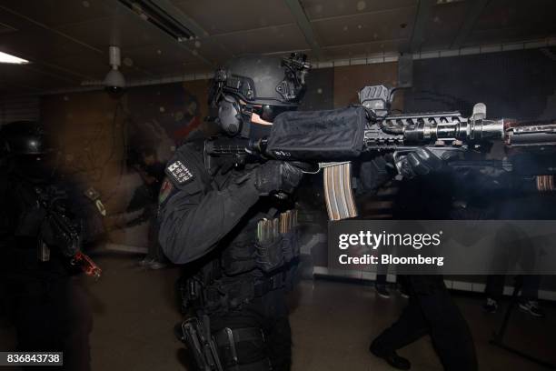 Police officers wearing gas masks aim their weapons during an anti-terror drill on the sidelines of the Ulchi Freedom Guardian military exercises at...