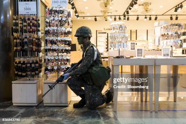 Soldier kneels in front of a jewelry store during an anti-terror drill on the sidelines of the Ulchi Freedom Guardian military exercises at a subway...