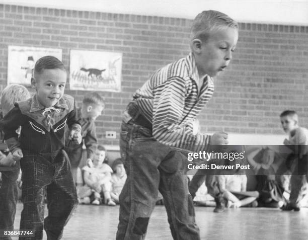 Bland Michael Stenbeck, 2265 W. Ford Pl., leads Paul Henry Suppes, 2200 W. Exposition, as they stalk make-believe Indians in time to a record played...