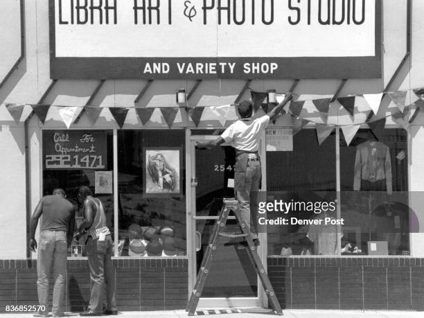 Photographer Willie Robinson, who owns Libra Art and Studio-t puts up decorations over his business place Thursday in preparation for the opening of...