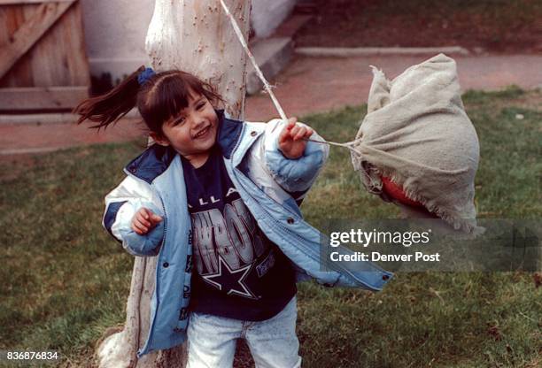 Mandy Molina plays with a tetherball in her backyard in West Denver. Credit: Denver Post