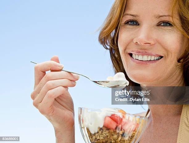 young woman eating healthy fruit breakfast by pool - yogurt ストックフォトと画像