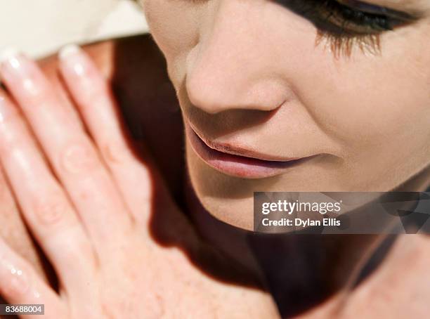 young woman with fair skin in sunshine. - woman hand face photos et images de collection