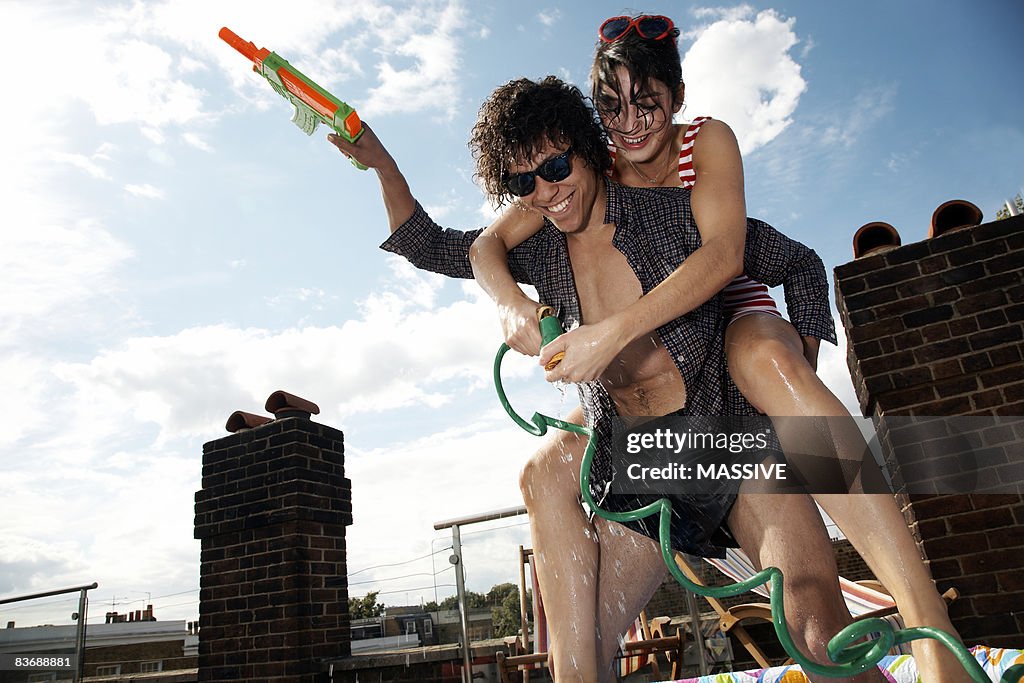 Girl on boy's back having a water fight