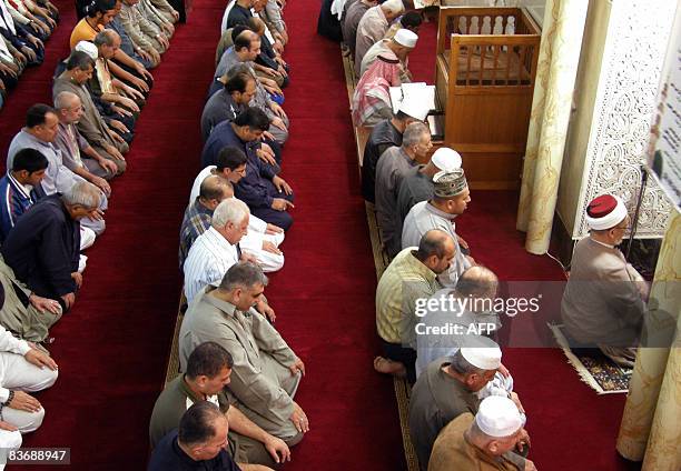 Following the Imam, Iraqi Sunni Muslims kneel as they take part in the Friday noon prayers at the Abu Hanifa mosque in the Adhamiyah district of...