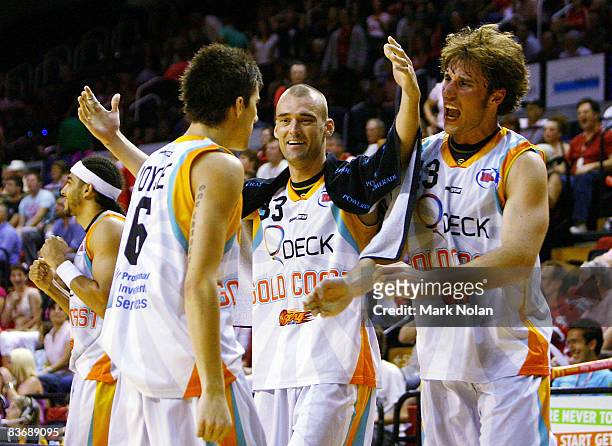 James Harvey and Casey Frank of the Blaze congratulate team-mate Daniel Joyce after the round nine NBL match between the Wollongong Hawks and the...