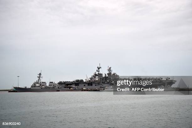 The guided-missile destroyer USS John S. McCain , seen with a hole on its portside after a collision with a tanker, docks next to the USS America at...