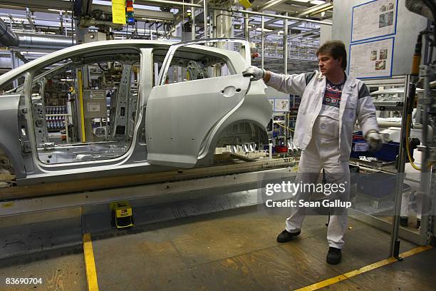 Worker attaches doors to the bodies of a new VW Golfs at the Volkswagen car factory on November 14, 2008 in Wolfsburg, Germany. Many European...