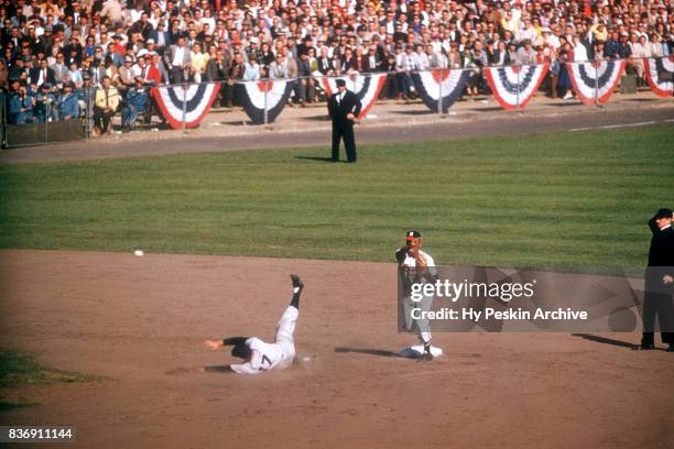 Felix Mantilla of the Milwaukee Braves throws to first as Enos Slaughter of the New York Yankees slides into second base during Game 5 of the 1957...