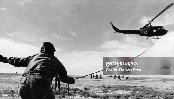 National Guard Colorado A Helicopter Hovers Over Colorado Army National Guarsmen At Buckley Air National Guard Base One paratrooper holds onto a...