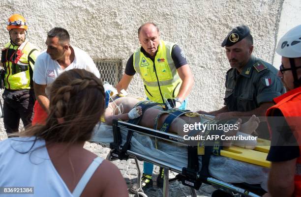 Italian emergency workers evacuate, on a stretcher, Mattias, a 7 year-old boy who was trapped by rubble, in Casamicciola Terme, on the Italian island...