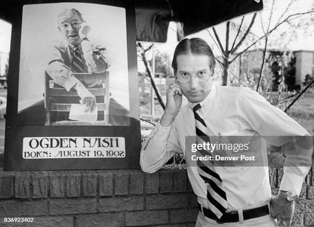 John Kokoska, originally from Boston, with U.S. Air Force, strikes pose next to Ogden Nash poster at lookalike party. Credit: The Denver Post