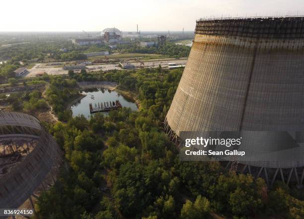 In this aerial view two partially-constructed and abandoned cooling towers stand as the new enclosure built over stricken reactor number four is seen...