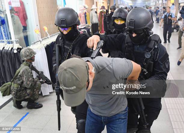 South Korean police officers capture a mock terrorist during an antiterrorism drill in a subway station in Seoul on Aug. 22, 2017. The drill was held...