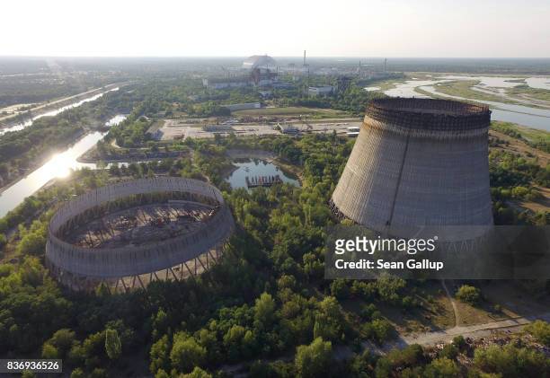 In this aerial view abandoned, partially-completed cooling towers stand at the Chernobyl nuclear power plant as the new, giant enclosure that covers...