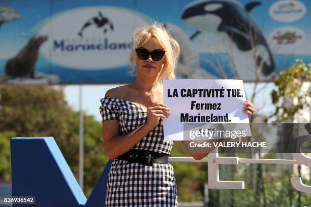 Actress Pamela Anderson holds a placard reading "captivity kills, shut Marineland" in front of French marine park Marineland, during a protest of the...