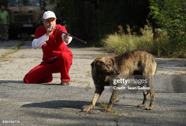 Pavel "Pasha" Burkatsky, a professional dog catcher from Kiev, takes aim with a blow gun to shoot a tranquilizer dart at a stray dog in the exclusion...