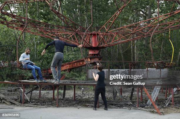 Tourists photograph one another on the remains of a merry-go-round in the ghost town of Pripyat not far from the Chernobyl nuclear power plant on...