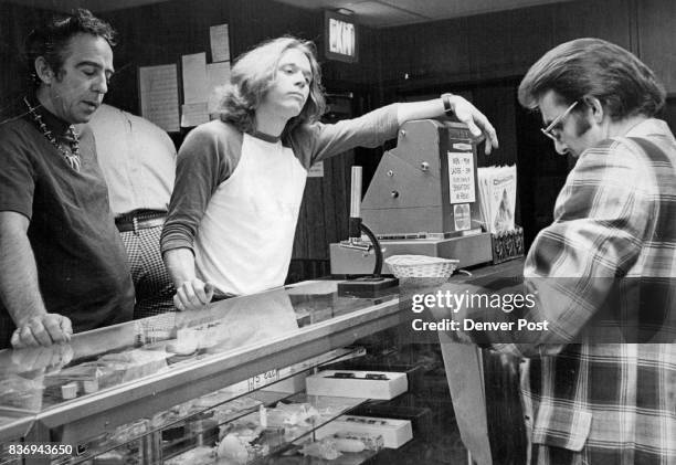 Detective John Thompson checks identification of Donald Williams, left, before arrest Mike Gordon, center Kitty's Central, Inc., projectionist,...