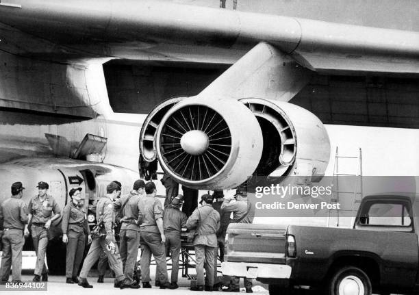 Air Force mechanics replace a faulty oil-pressure gaugee on one of twon C-141 cargo planes used to transfer Weteyes. The faulty gauge caused the...