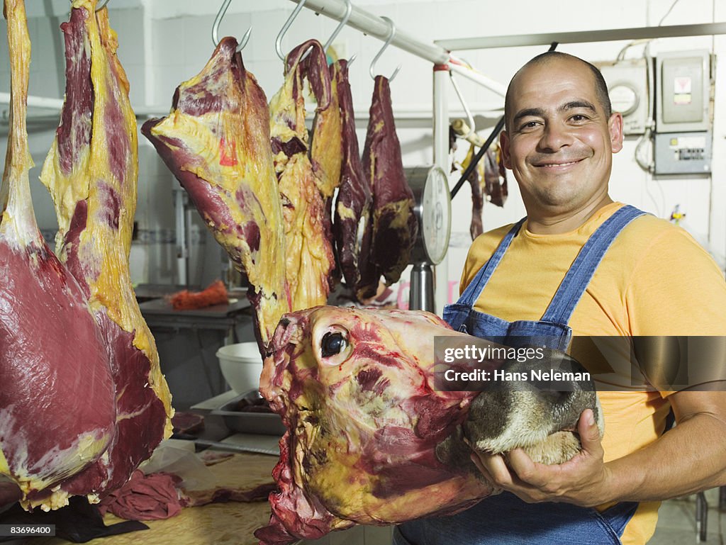 Butcher holding slaughtered cow's head
