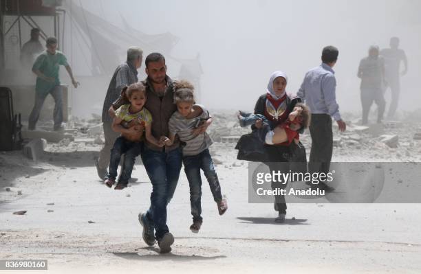 Civilians escape from explosion site after Assad Regime's forces strike over the de-conflict zone, Ein Tarma Town of Eastern Ghouta region of...