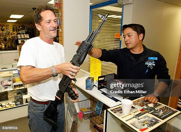 The Gun Store rangemaster Heu Thao shows Gregory Smith of Nevada the modifications made to his AK-47 assault rifle November 14, 2008 in Las Vegas,...