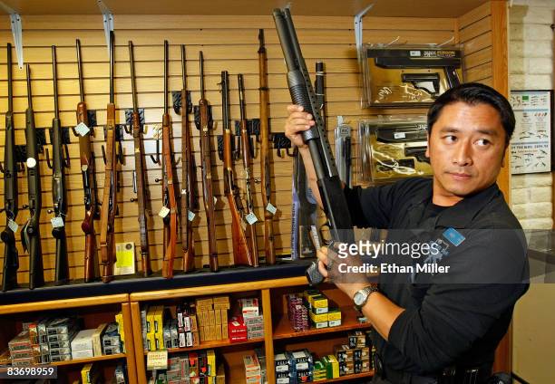 The Gun Store rangemaster Heu Thao shows a customer a shotgun November 14, 2008 in Las Vegas, Nevada. Store manager Cliff Wilson said he's seen a...