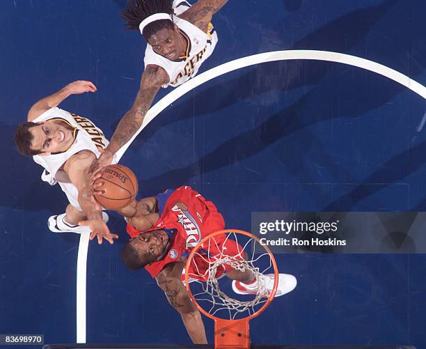 Andre Iguodala $9 of the Philadelphia 76ers rebounds over Jerff Foster and Marquis Daniels of the Indiana Pacers at Conseco Fieldhouse on November...