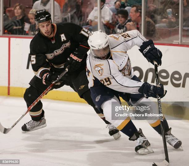 Brad Larsen of the Nashville Predators handles the puck alongside the boards as Ryan Getzlaf of the Anaheim Ducks defends from behind during the game...