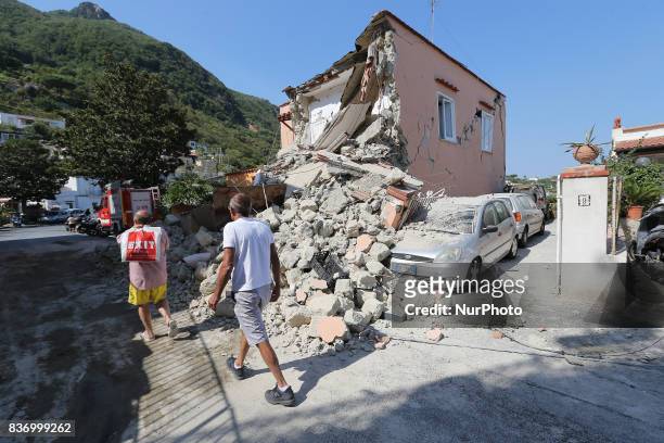 People walk near an house destroyed in the earthquake in one of the more heavily damaged areas on August 22, 2017 in Casamicciola Terme, Italy. A...