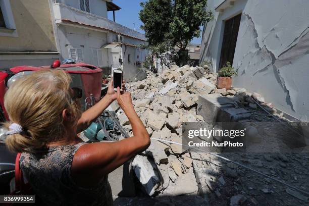 Woman take a picture near a damaged building by earthquake in one of the more heavily damaged areas on August 22, 2017 in Casamicciola Terme, Italy....