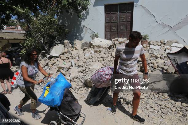 People walk near a house, destroyed in the earthquake in one of the more heavily damaged areas on August 22, 2017 in Casamicciola Terme, Italy. A...