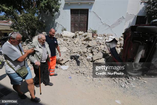 People walk near a house, destroyed in the earthquake in one of the more heavily damaged areas on August 22, 2017 in Casamicciola Terme, Italy. A...