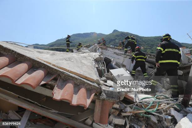 Rescuers team walk near a house, destroyed in the earthquake in one of the more heavily damaged areas on August 22, 2017 in Casamicciola Terme,...