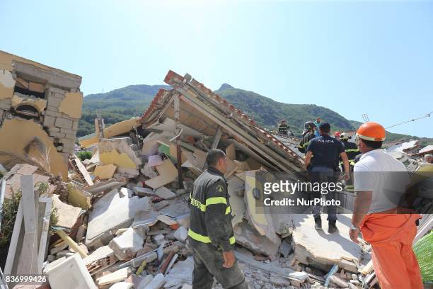 Rescuers team walk near a house, destroyed in the earthquake in one of the more heavily damaged areas on August 22, 2017 in Casamicciola Terme,...
