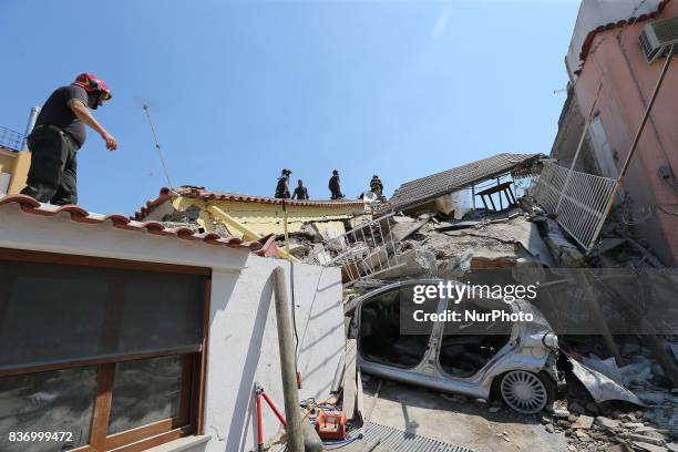 Rescuers team walk near a house, destroyed in the earthquake in one of the more heavily damaged areas on August 22, 2017 in Casamicciola Terme,...