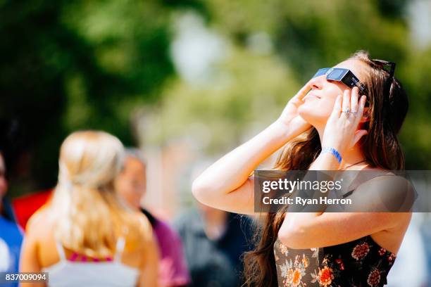 spectators look on to the solar eclipse - eclipse solar imagens e fotografias de stock