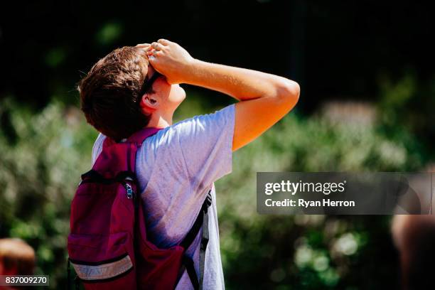 spectators look on to the solar eclipse - woman eclipse stock pictures, royalty-free photos & images