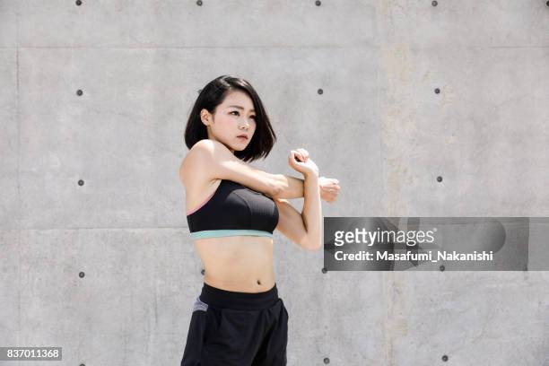 healthy japanese woman is stretching outdoors - beautiful japanese women stock pictures, royalty-free photos & images