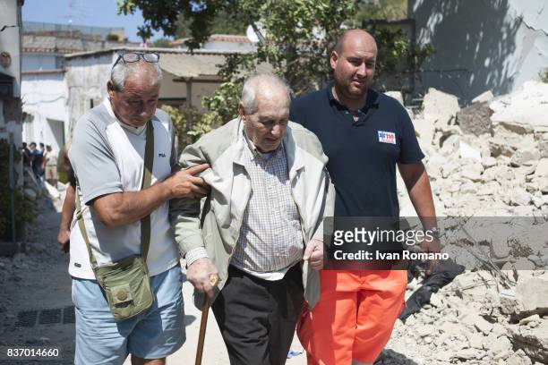Rescuers help an elderly man to leave one of the areas most affected by the earthquake on August 22, 2017 in Casamicciola Terme, Italy. A...