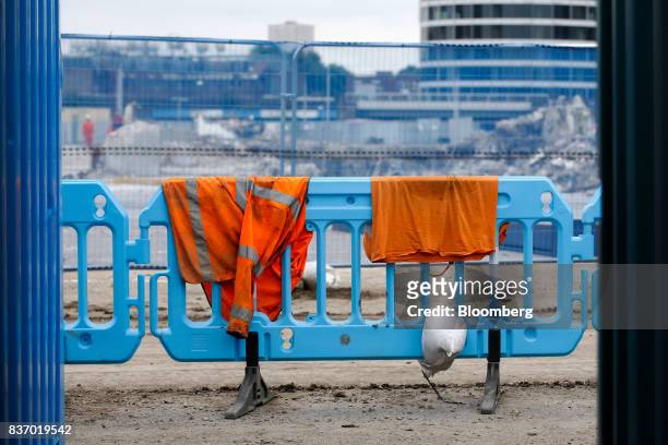 High-visibility jacket and sandbag sit on fencing as demolition work takes place at the Nine Elms Square construction site in London, U.K., on...