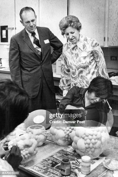 Neil Roberts and Mrs. Alma Heine, 2729 Simms St., look over shoulder of Alberta Gonzales, 1146 32nd St., as she works on ceramic project at the...