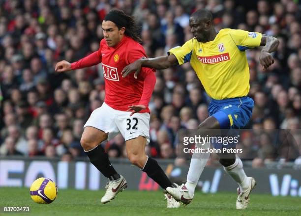 Carlos Tevez of Manchester United clashes with Seyi Olofinjana of Stoke City during the Barclays Premier League match between Manchester United and...