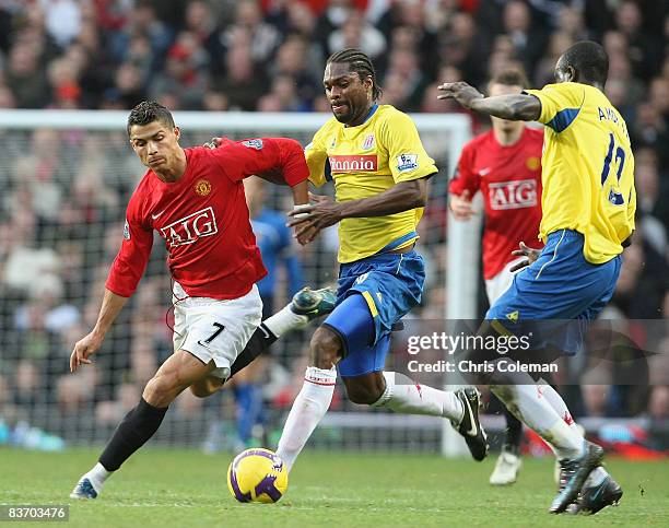 Cristiano Ronaldo of Manchester United clashes with Salif Diao and Amdy Faye of Stoke City during the Barclays Premier League match between...